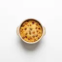 Milchreis gesüßt, mit Milch 3,5 % Fett und Rosinen, aufgezogen, gebacken