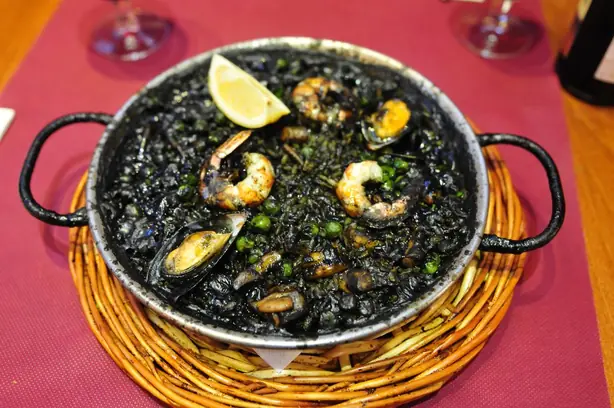 Foto von Valencianischer Arròs Negre mit Tintenfisch – fertig angerichtet