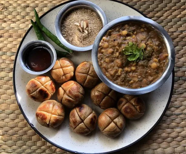 Foto von Rajasthani Bati mit Dal und Ghee – fertig angerichtet