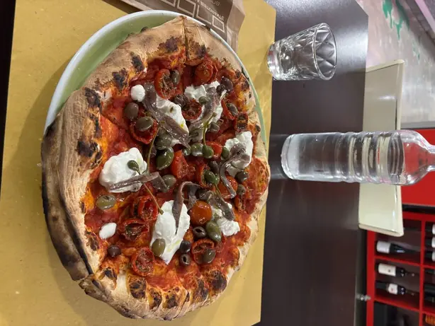 Pizza with anchovies, caper, cherry tomatoes and strachiattella – Foto: Robot8A (CC BY-SA 4.0)