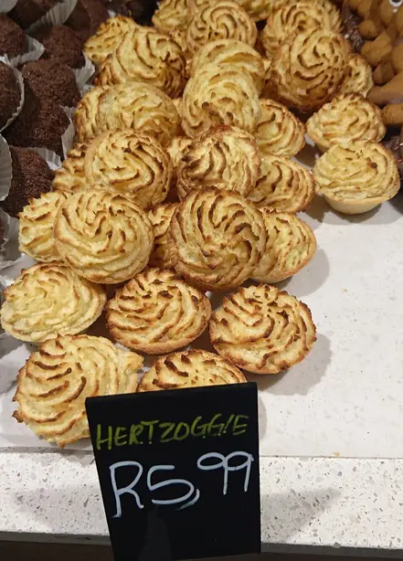 Foto von Hertzoggies - Südafrikanische Kokos-Baiser-Törtchen mit Aprikosenkern – fertig angerichtet