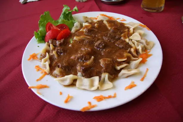 Foto von Idrijski žlikrofi – Traditionelle slowenische Kartoffelteigtaschen – fertig angerichtet