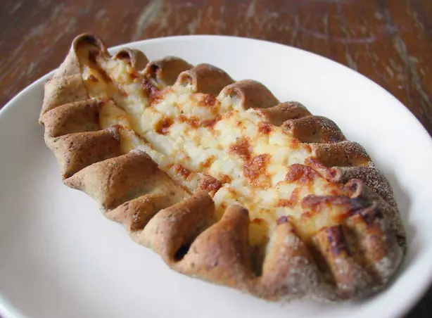 Foto von Karjalanpiirakka – Traditionelle karelische Roggenpasteten mit Milchreisfüllung – fertig angerichtet