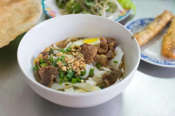 Foto von Mì Quảng - Vietnamesische Kurkuma-Nudeln mit Schweinebauch & Garnelen – fertig angerichtet